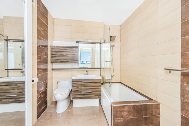 full bath featuring tile patterned floors, vanity, tile walls, and bathing tub / shower combination