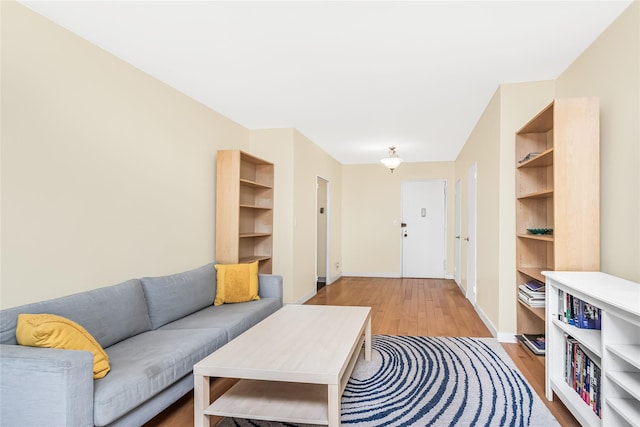 living area with light wood-type flooring and baseboards