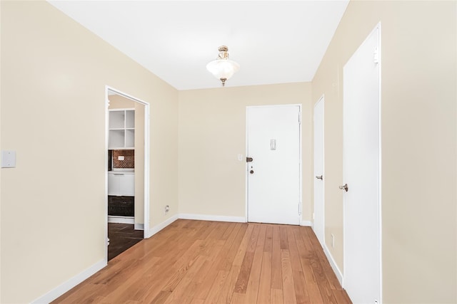 foyer with baseboards and light wood-type flooring