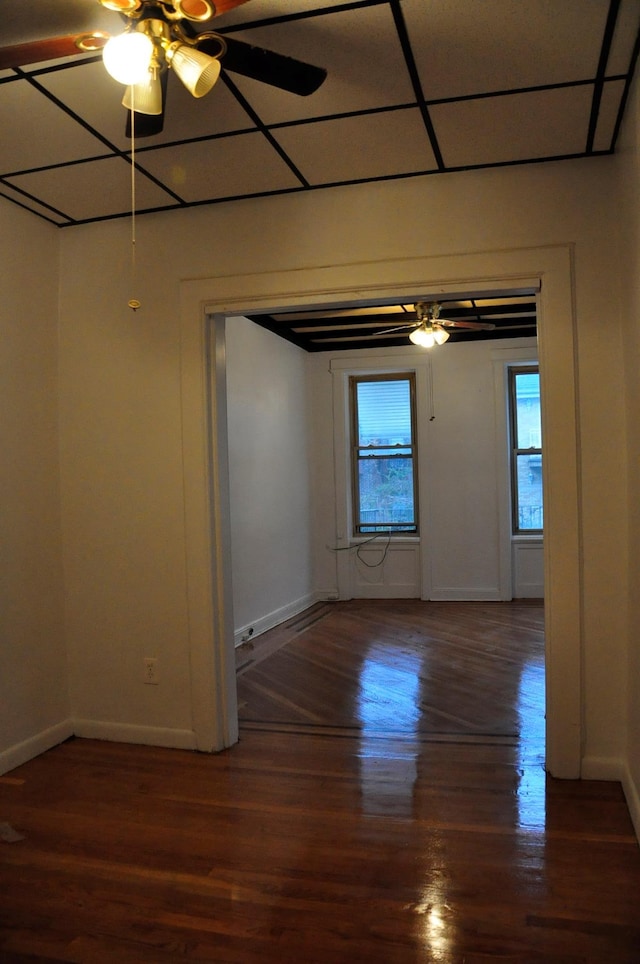 unfurnished room with a ceiling fan, baseboards, and wood finished floors