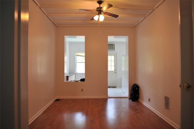 spare room featuring a ceiling fan, wood finished floors, visible vents, and baseboards