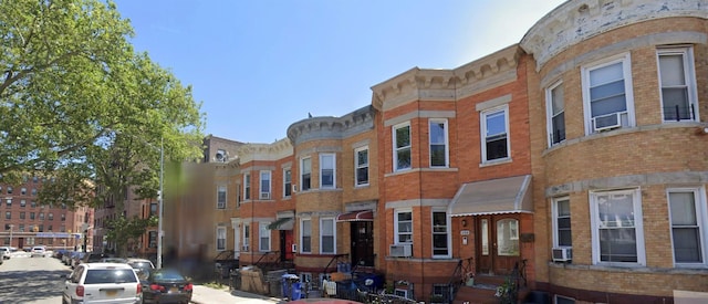 view of front of home with cooling unit and brick siding