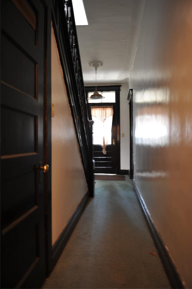 hallway featuring stairway and baseboards