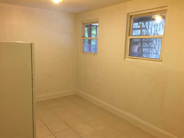 empty room featuring light tile patterned floors and baseboards