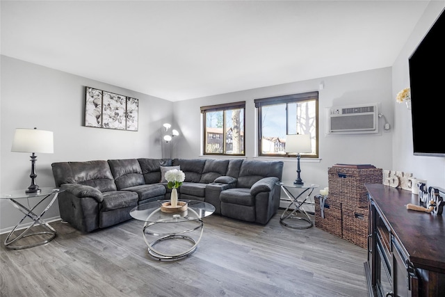 living area with baseboard heating, wood finished floors, and a wall mounted AC