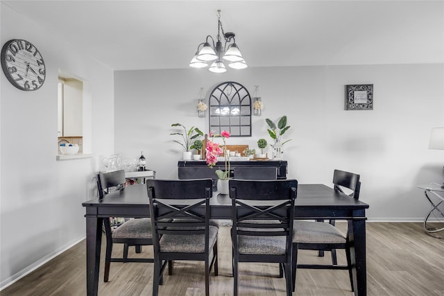 dining room with an inviting chandelier, wood finished floors, and baseboards