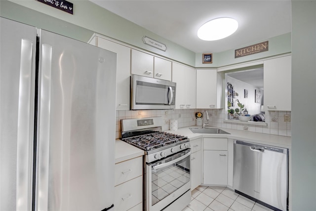 kitchen with a sink, stainless steel appliances, decorative backsplash, and light countertops