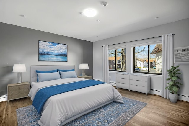 bedroom featuring a baseboard radiator, baseboard heating, and wood finished floors