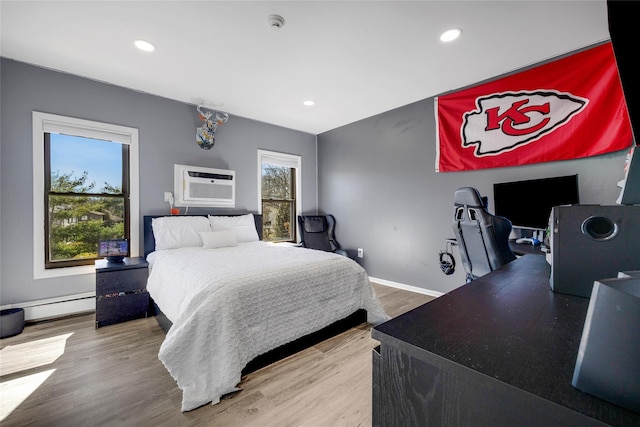 bedroom featuring a baseboard heating unit, wood finished floors, a wall unit AC, recessed lighting, and baseboards