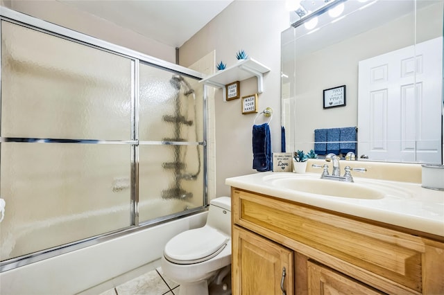 bathroom featuring vanity, tile patterned floors, toilet, and shower / bath combination with glass door