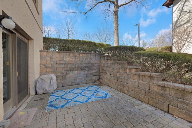 view of patio with fence and a grill