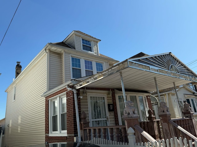 view of front of home with brick siding and a porch