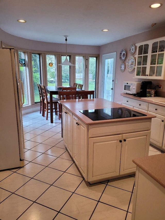kitchen featuring a wealth of natural light, white cabinets, white appliances, and glass insert cabinets