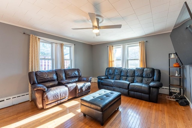 living room featuring crown molding, light wood finished floors, and baseboard heating