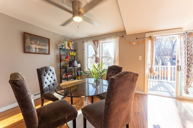 dining space with ceiling fan, a baseboard radiator, baseboards, and light wood-style flooring