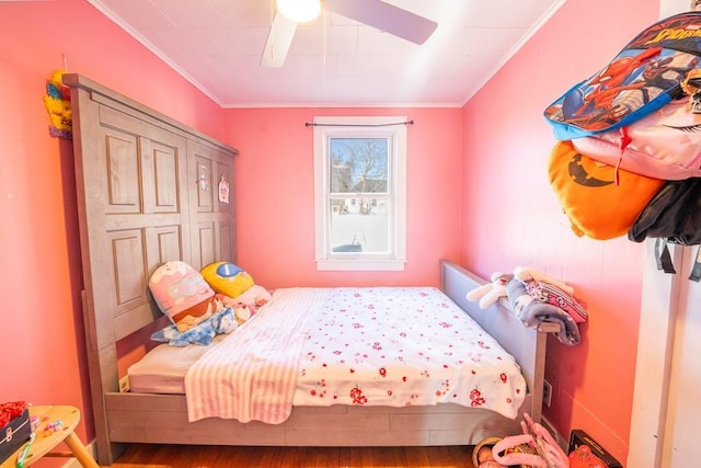 bedroom with crown molding, a ceiling fan, and wood finished floors