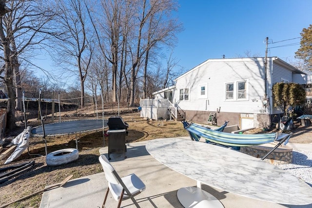 view of yard with a trampoline and a patio area