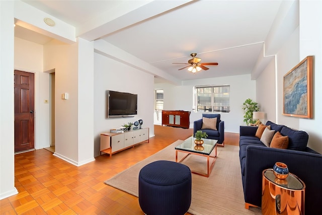 living room featuring baseboards, beam ceiling, and a ceiling fan