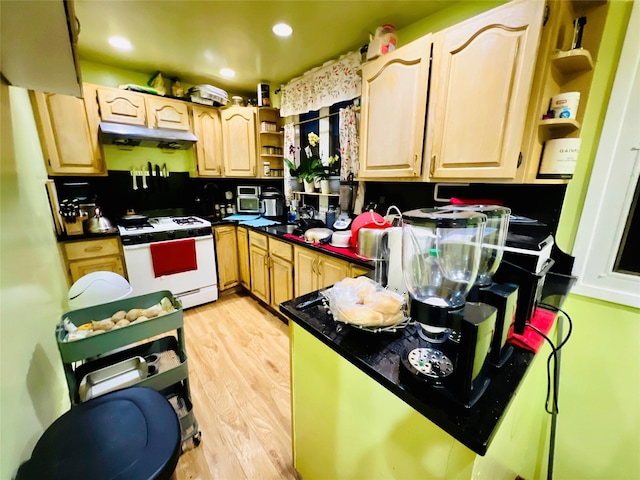 kitchen featuring open shelves, white range with gas stovetop, light wood-style floors, under cabinet range hood, and dark countertops