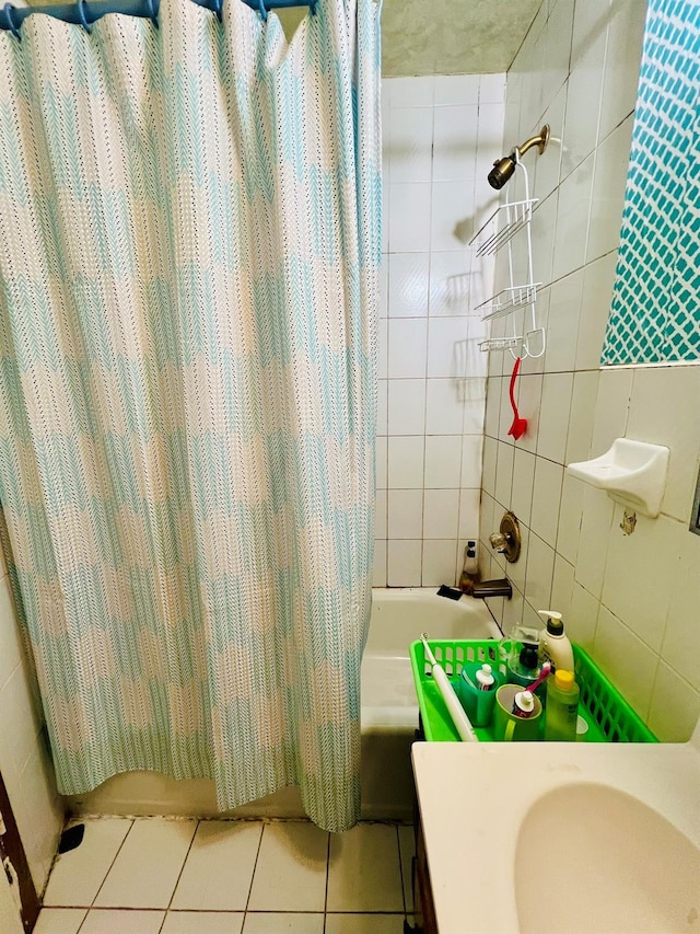 full bathroom featuring shower / bathtub combination with curtain, tile walls, vanity, and tile patterned flooring