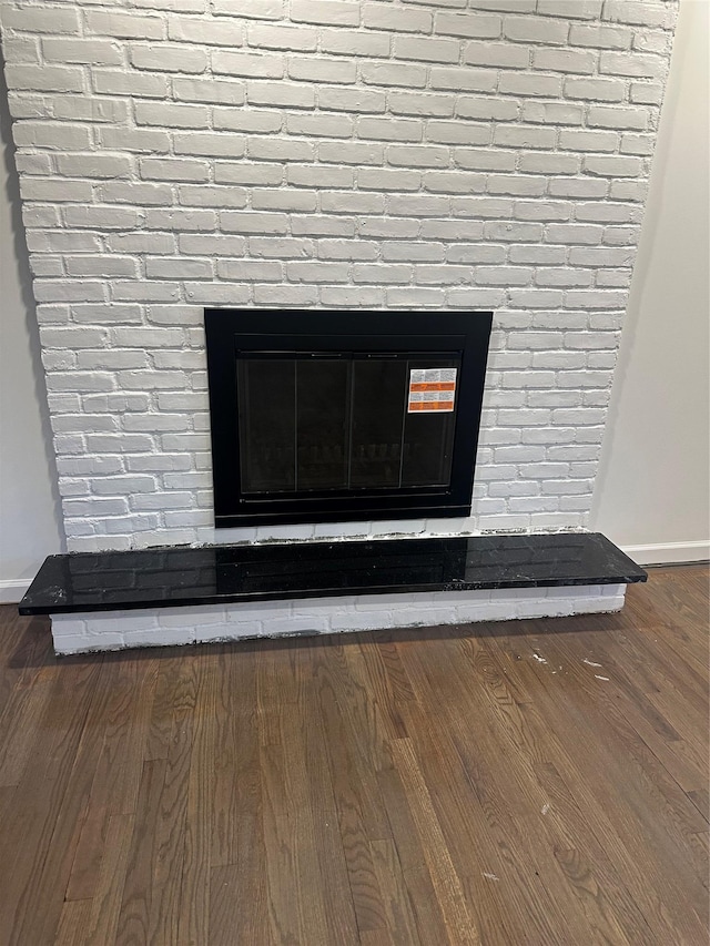 interior details featuring baseboards, wood finished floors, and a fireplace