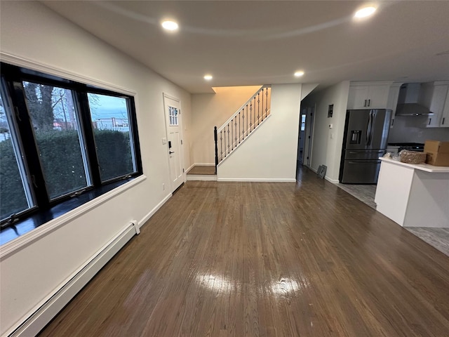 unfurnished living room with recessed lighting, stairway, a baseboard radiator, baseboards, and dark wood-style flooring