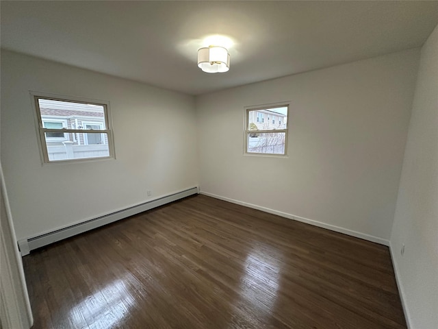 empty room with baseboard heating, baseboards, and dark wood-style flooring