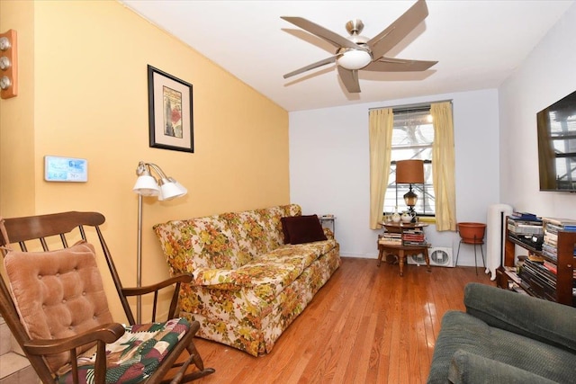 living area with a ceiling fan and wood finished floors