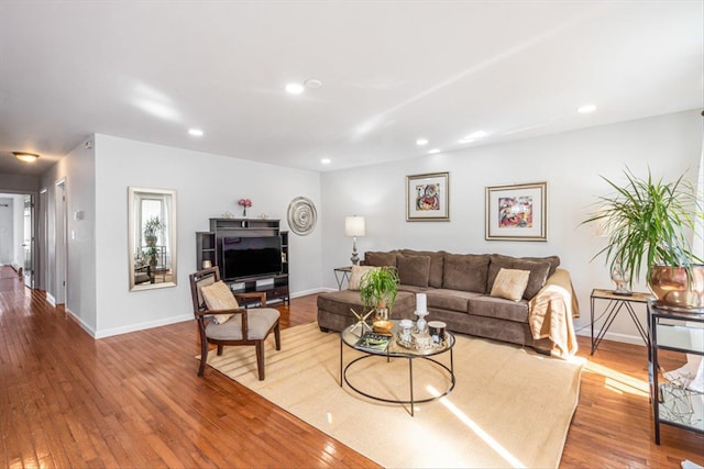 living area featuring recessed lighting, baseboards, and hardwood / wood-style floors