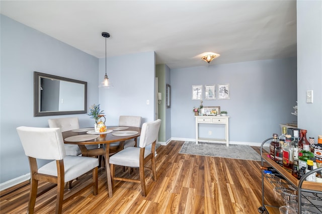 dining space featuring baseboards and wood finished floors