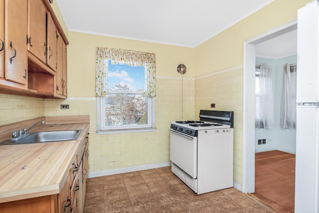 kitchen with visible vents, a healthy amount of sunlight, white gas range, and a sink