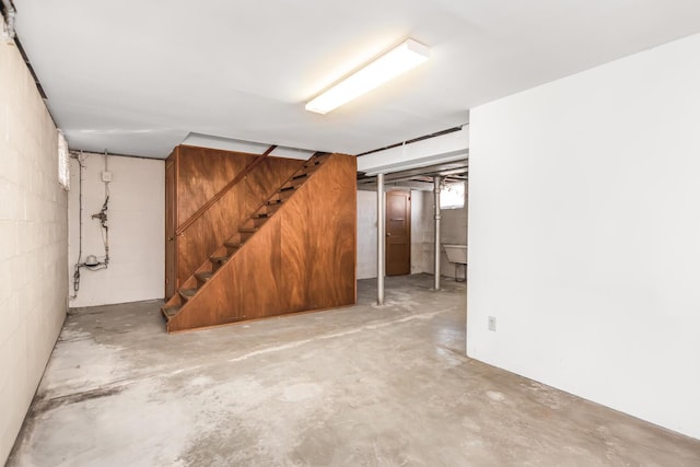 basement with stairs and concrete block wall