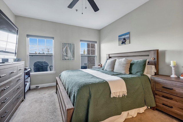 bedroom featuring baseboards, light colored carpet, and a ceiling fan