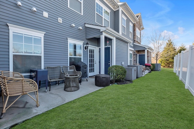 back of property with a patio, central air condition unit, a yard, and fence