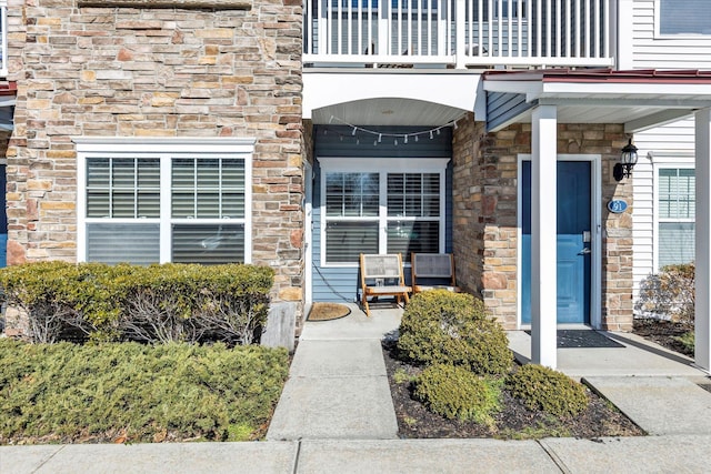 entrance to property featuring a balcony and covered porch