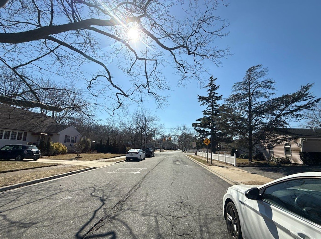 view of road with curbs, traffic signs, and sidewalks