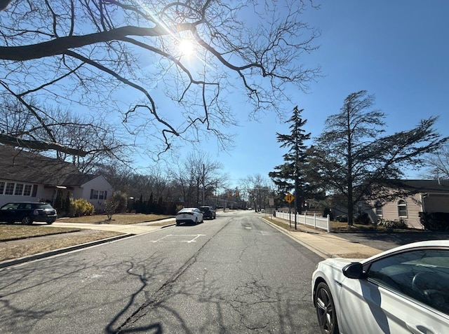 view of road with curbs, traffic signs, and sidewalks