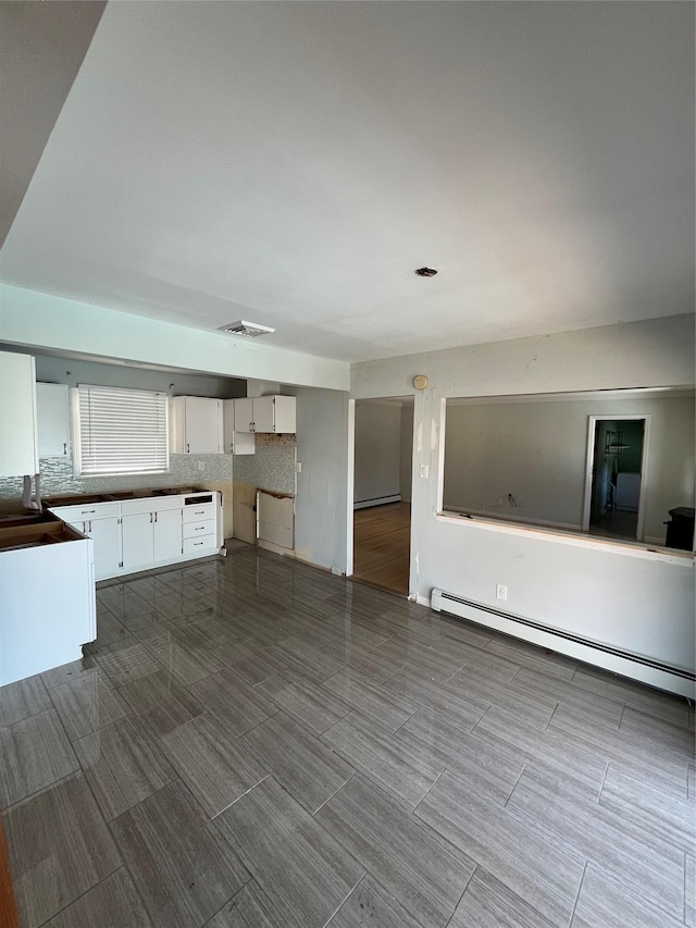 interior space featuring a baseboard heating unit and visible vents