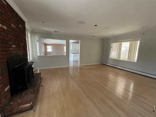 unfurnished living room featuring crown molding, baseboards, baseboard heating, a wood stove, and light wood-style floors