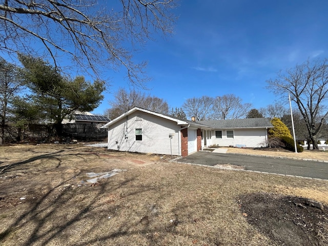 ranch-style house featuring aphalt driveway, a garage, and brick siding