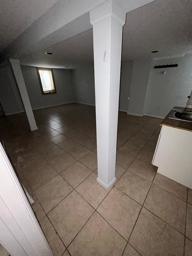 basement with light tile patterned floors and a textured ceiling