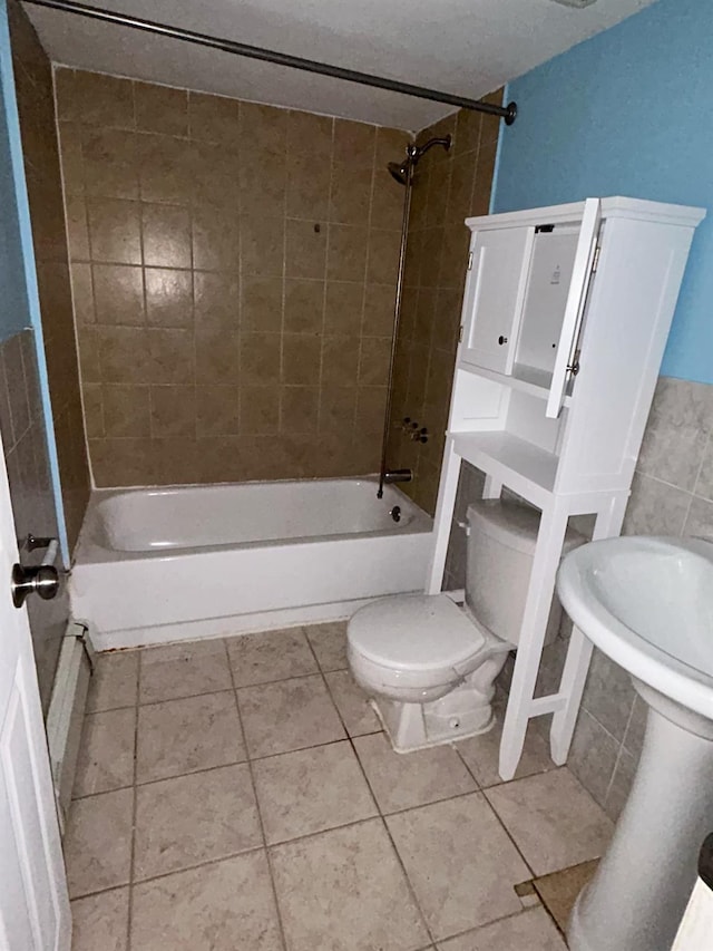 bathroom featuring tile patterned floors, toilet, and shower / washtub combination