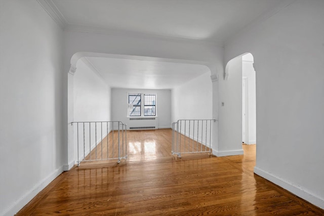 3636 Greystone Ave Unit 6M, Bronx, NY 10463 - empty room with arched walkways, crown molding, radiator heating unit, and wood finished floors