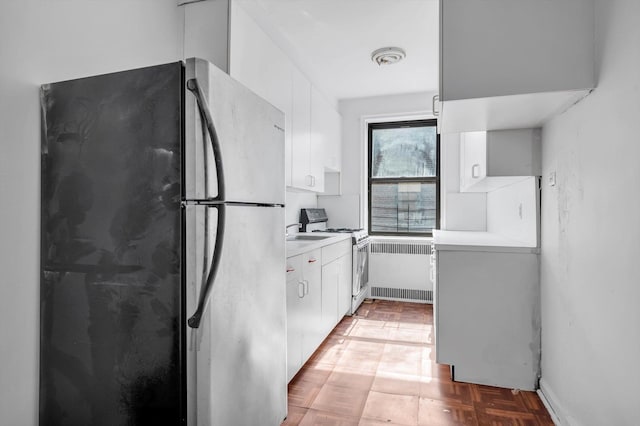 3636 Greystone Ave Unit 6M, Bronx, NY 10463 - kitchen with gas range gas stove, radiator heating unit, white cabinetry, freestanding refrigerator, and light countertops