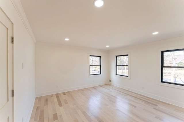 empty room with recessed lighting, baseboards, light wood-style floors, and ornamental molding