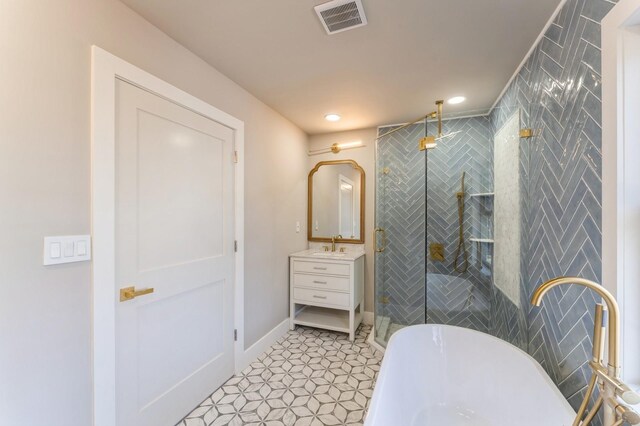 full bathroom featuring vanity, visible vents, recessed lighting, a freestanding bath, and a shower stall