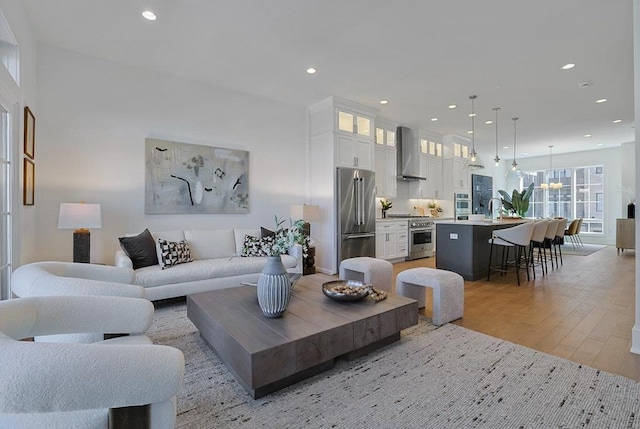 living room featuring recessed lighting, light wood-type flooring, and a chandelier