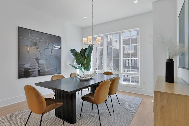 dining area with light wood-style flooring, a notable chandelier, recessed lighting, and baseboards