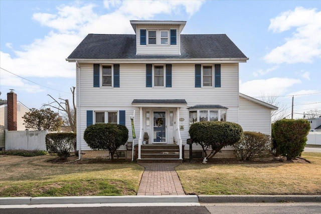 american foursquare style home with a front yard and fence