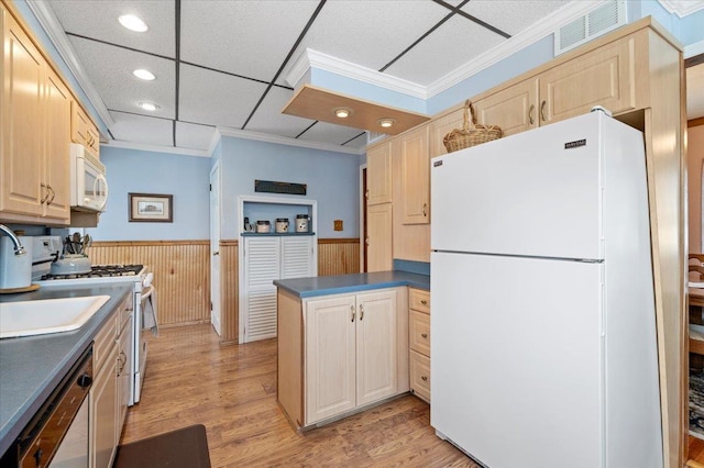 kitchen with light wood finished floors, visible vents, wainscoting, and white appliances